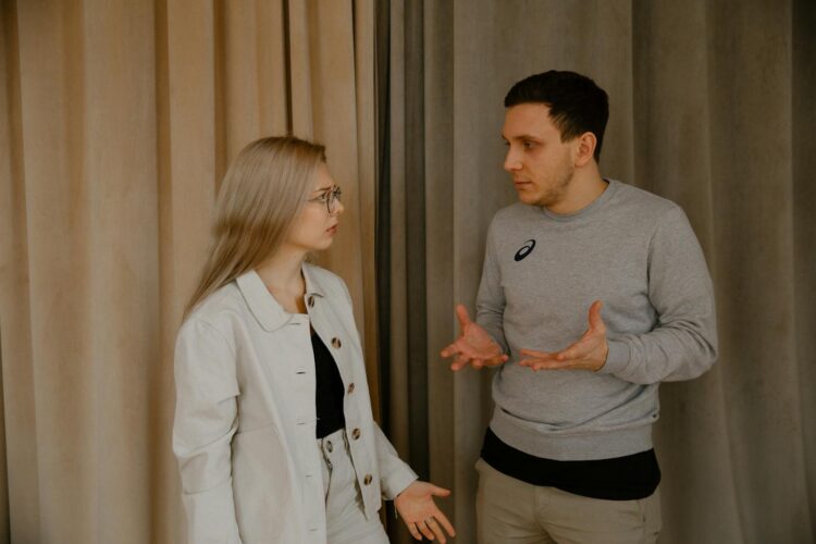 A young couple passionately discussing indoors, capturing intense emotions and gestures.