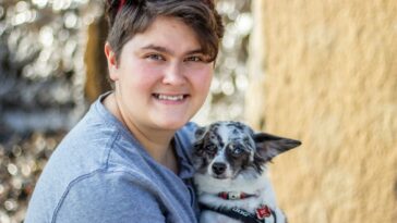 a woman holding a small dog in her arms