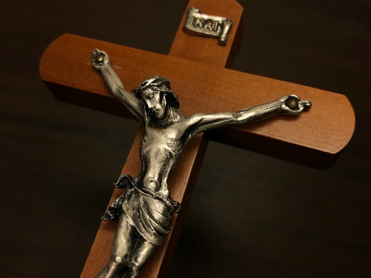 a silver crucifix on a wooden cross