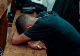 a man is sleeping on a wooden bench