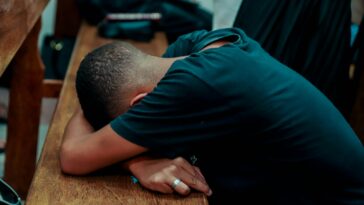 a man is sleeping on a wooden bench