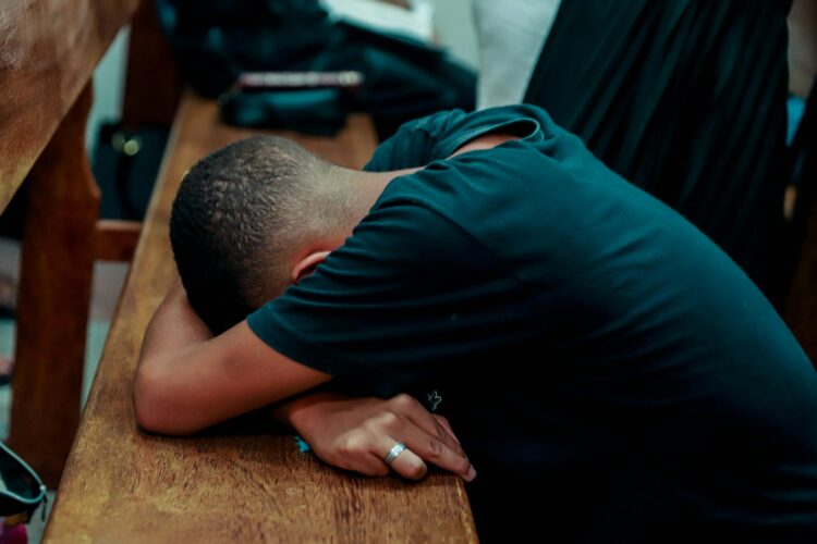 a man is sleeping on a wooden bench