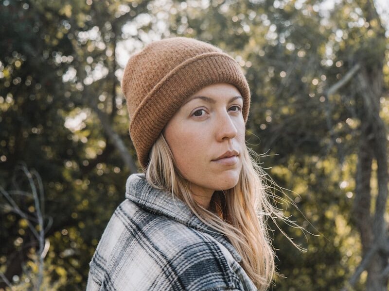 woman in brown knit cap and plaid shirt