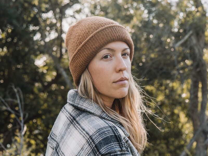 woman in brown knit cap and plaid shirt
