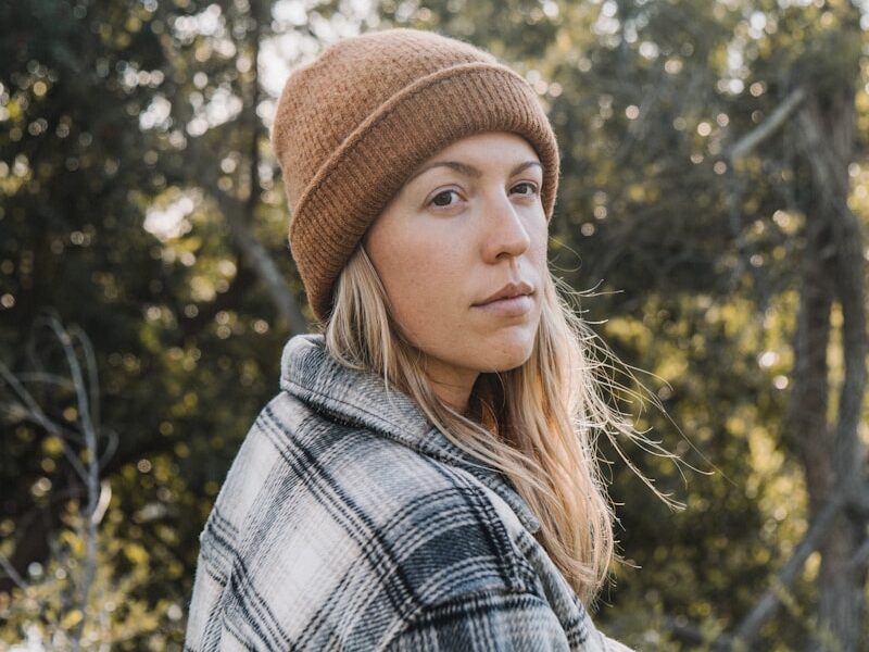woman in brown knit cap and plaid shirt