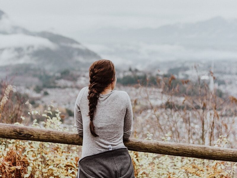 standing woman in grey long-sleeved shirt
