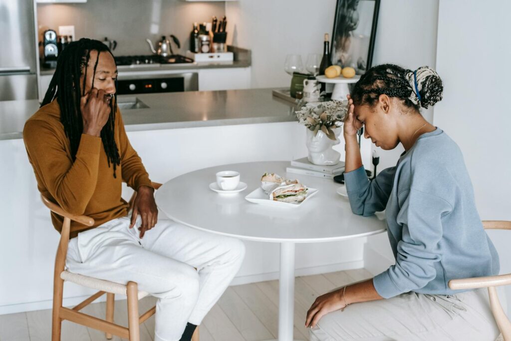 Young couple having a serious and expressive conversation in a modern kitchen setting.