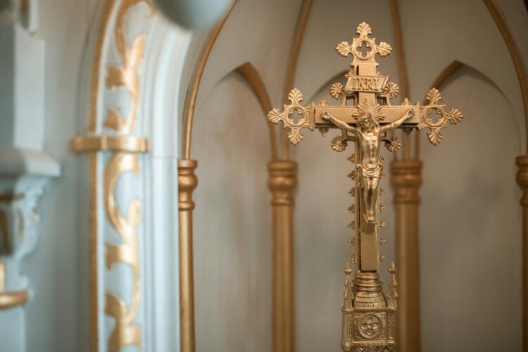 Beautiful ornate golden crucifix in a church with detailed decor.