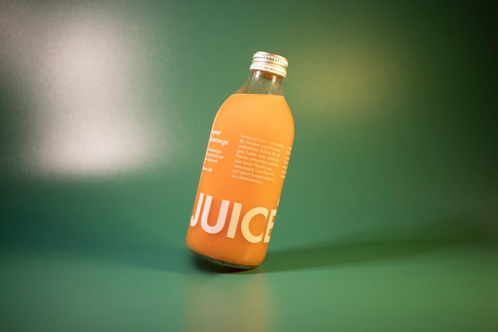 a bottle of juice sitting on a green surface