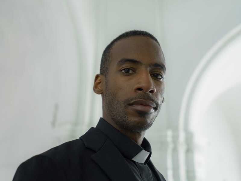 Side profile of a male clergyman in a church, exuding confidence and faith.