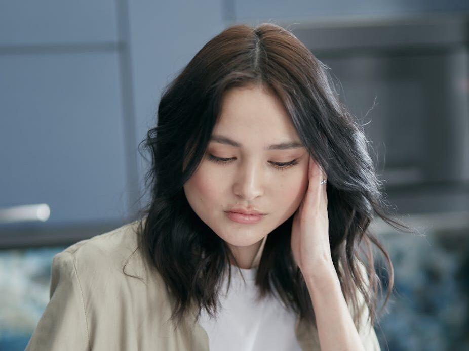 Young woman reviewing paperwork at home, focused and concerned.