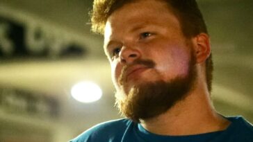 A man with a beard looks to the side.