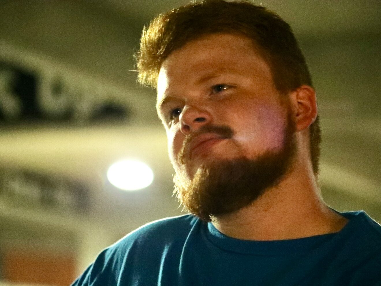 A man with a beard looks to the side.