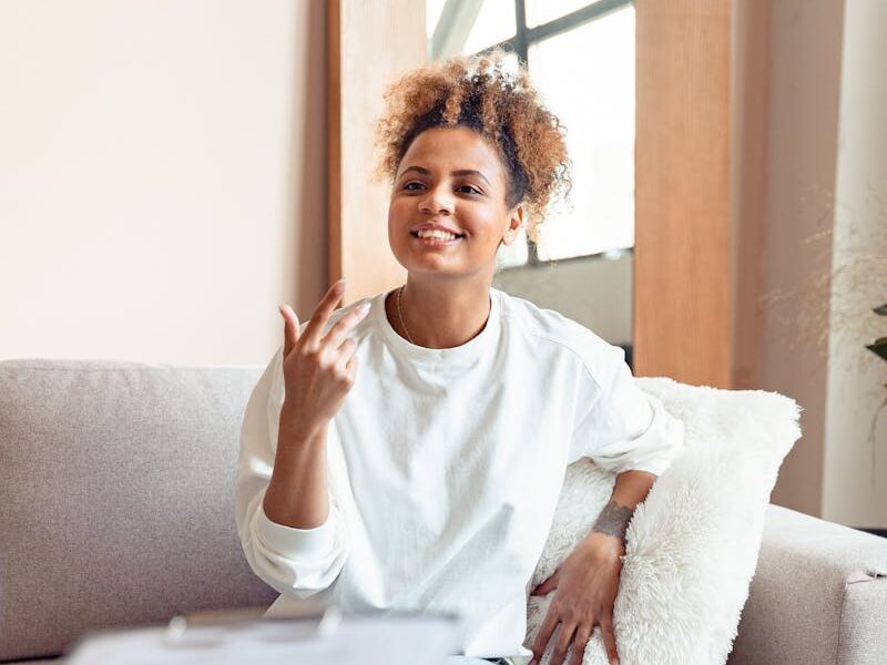 Smiling woman in a therapy session on a comfortable sofa.