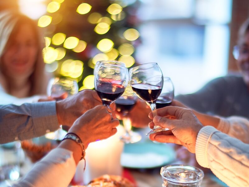 woman in white long sleeve shirt holding wine glass