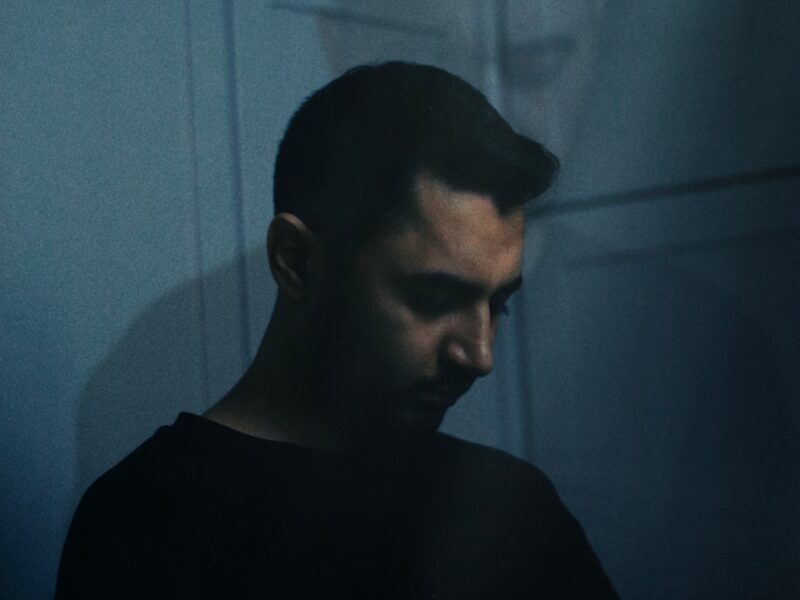 a man standing in front of a wall with a shadow on it