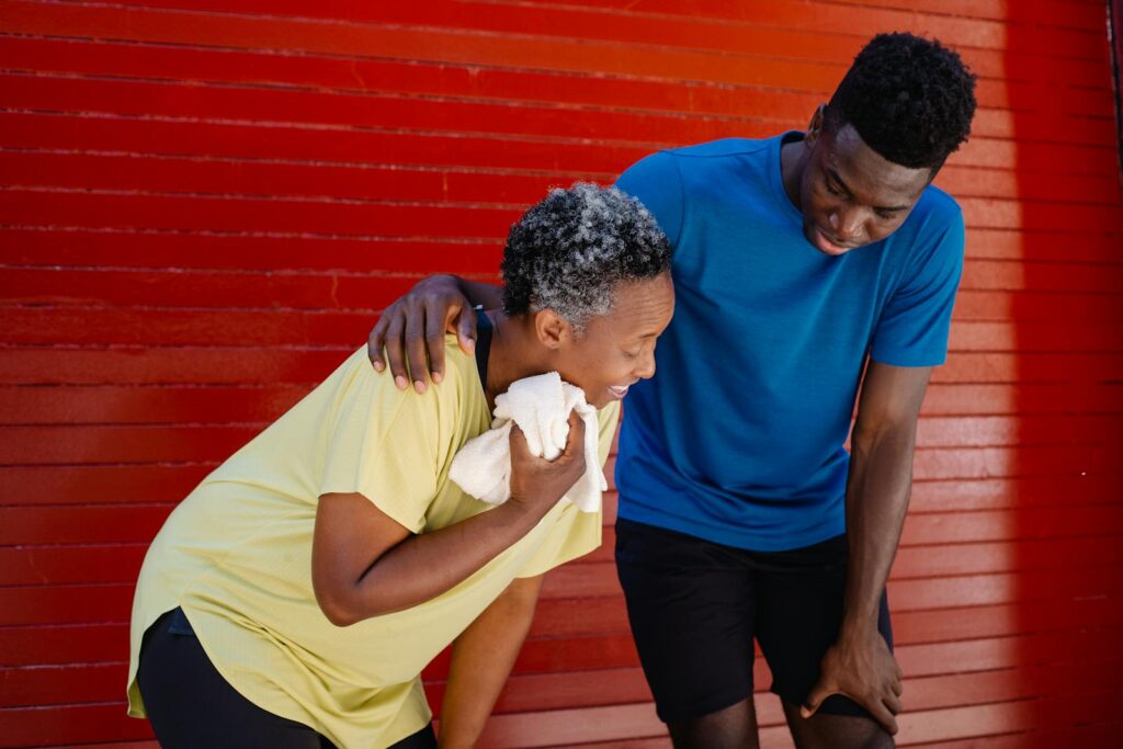 Elderly couple taking a rest after a workout, displaying exhaustion.