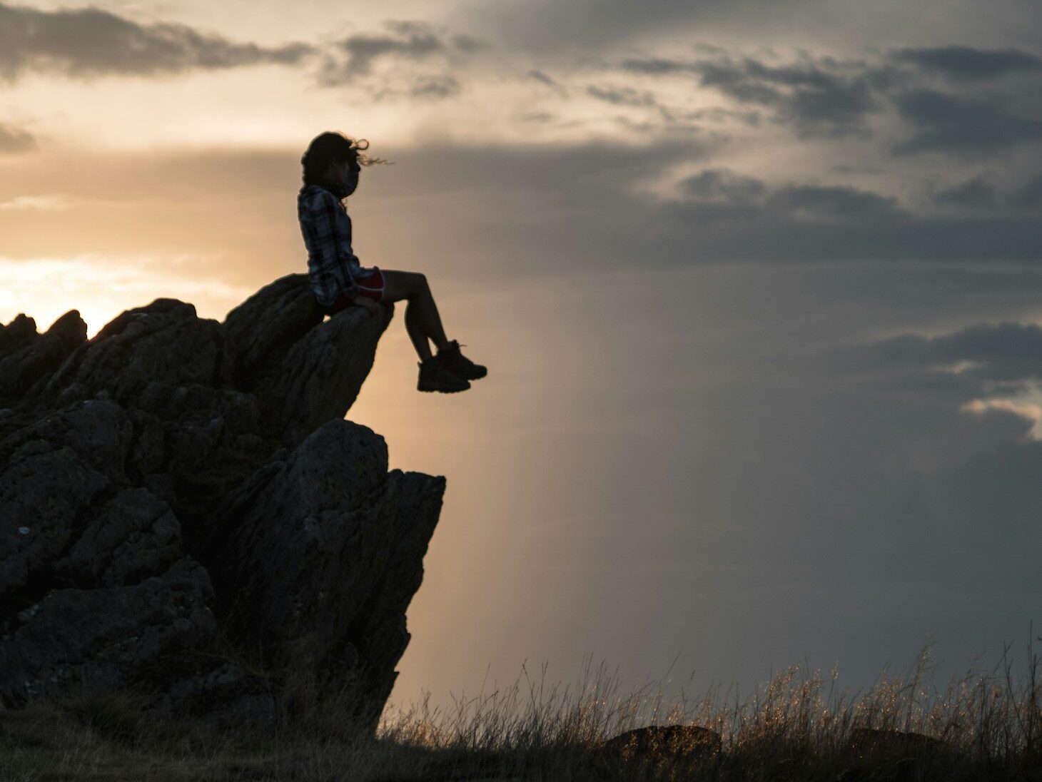 a person sitting on top of a large rock
