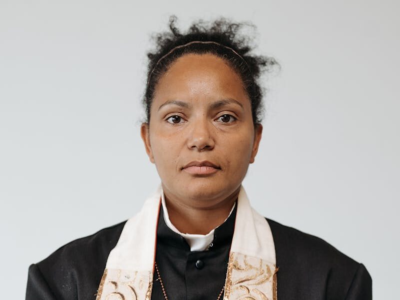Portrait of a female pastor holding a Holy Bible, symbolizing faith and religion.