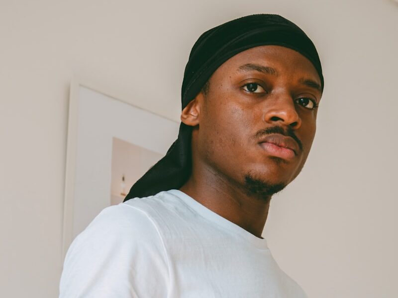 man in white crew neck t-shirt wearing black cap