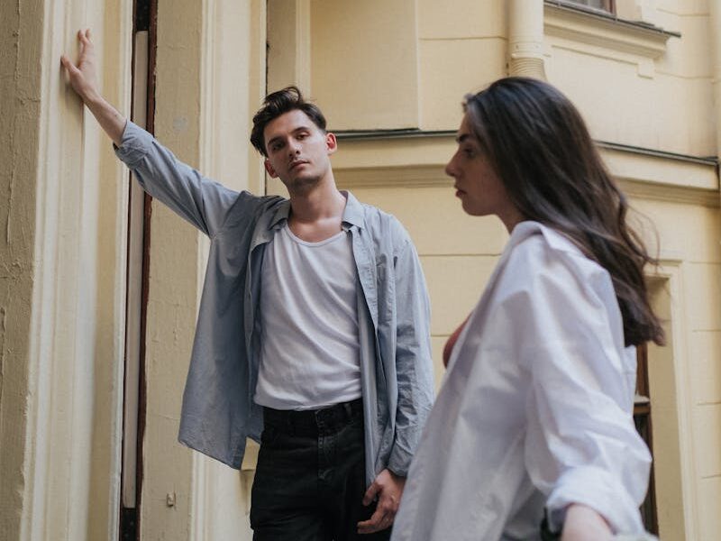 A couple having a serious discussion on a balcony, expressing tension and misunderstanding.