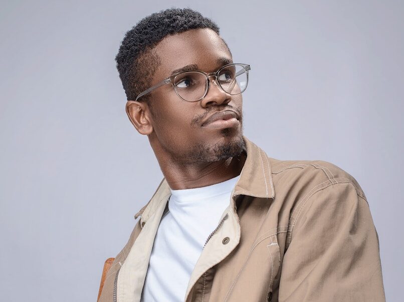 man in brown button up jacket wearing black framed eyeglasses