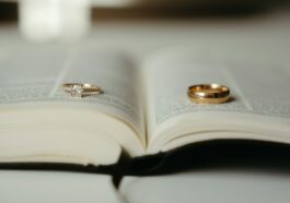 A close up of two wedding rings on an open book