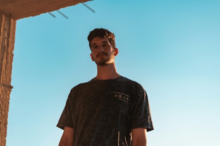 man in black crew neck t-shirt standing under blue sky during daytime