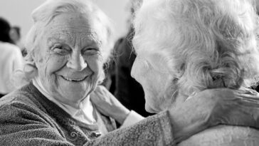 grayscale photo of woman in sweater smiling