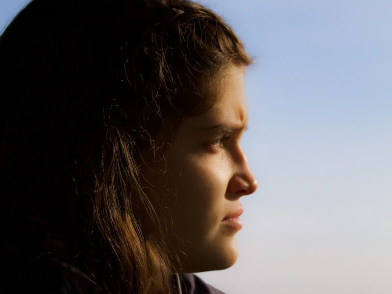 a woman looking out the window of a bus