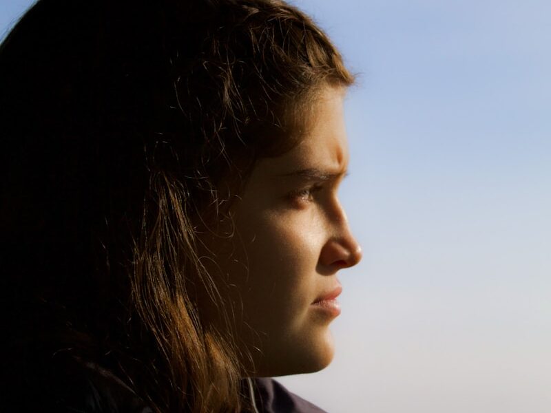 a woman looking out the window of a bus