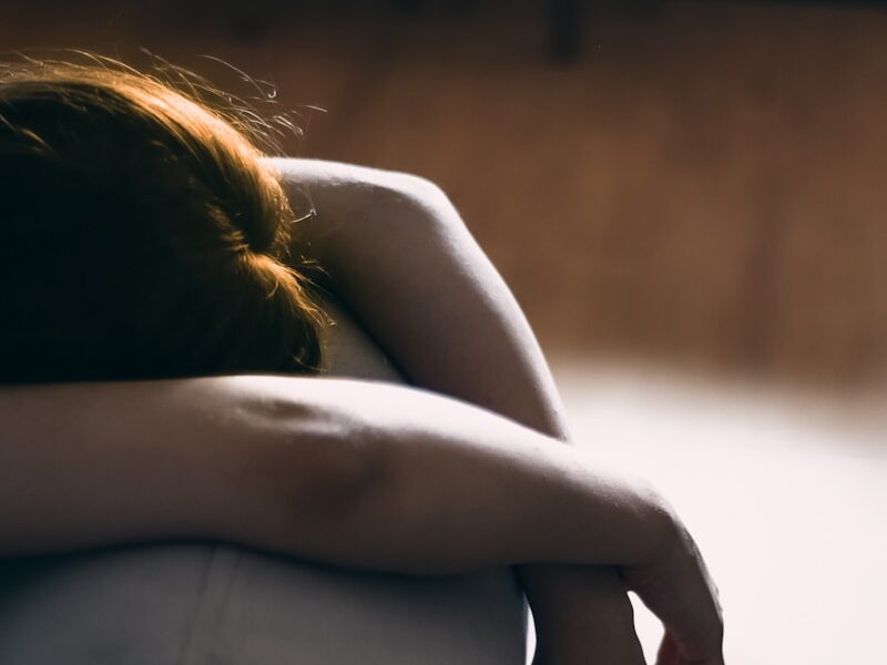woman in black dress lying on gray couch