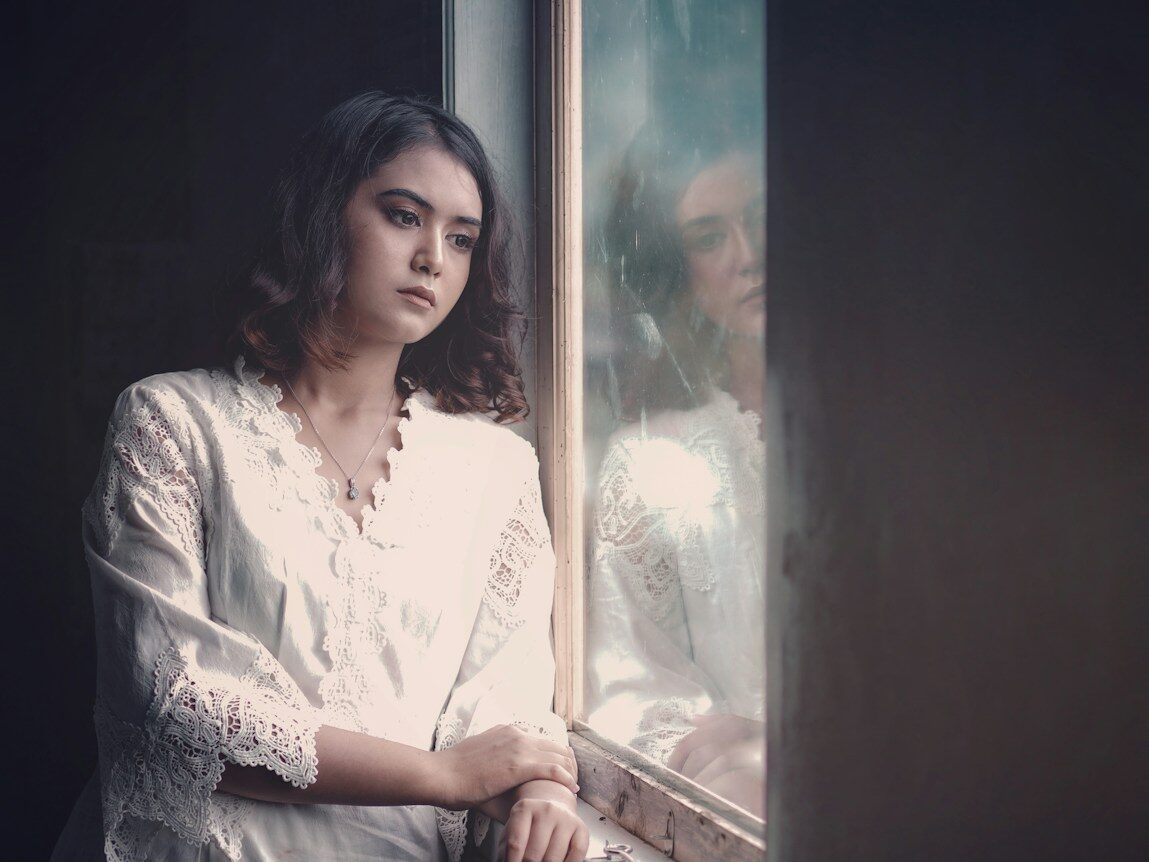 a woman is looking out of a window
