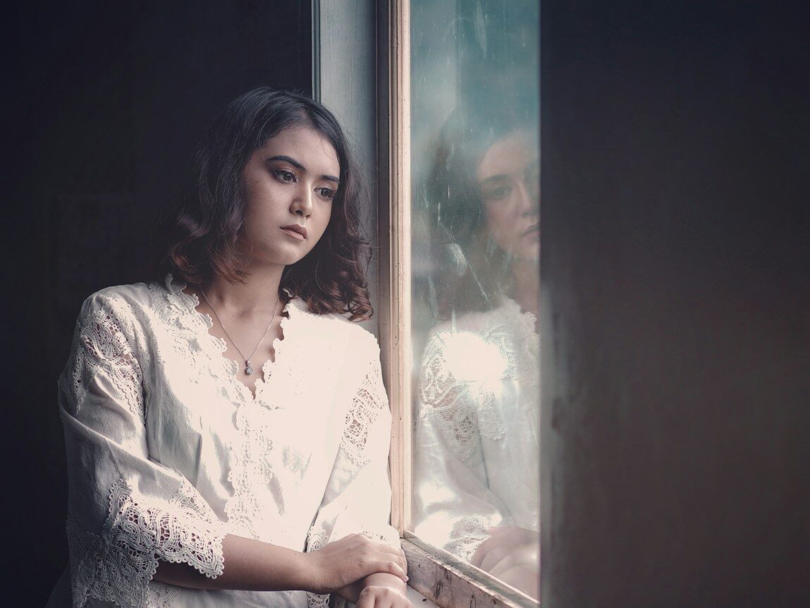 a woman is looking out of a window