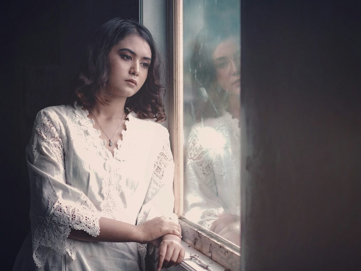 a woman is looking out of a window