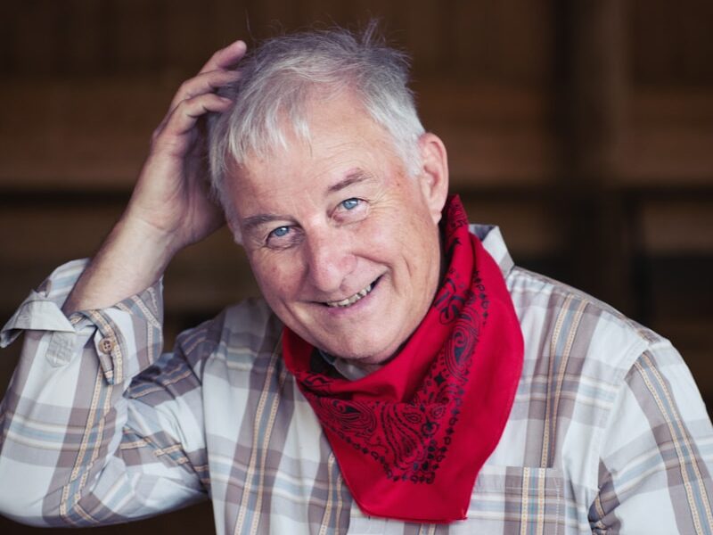 man in white and black plaid dress shirt wearing red scarf