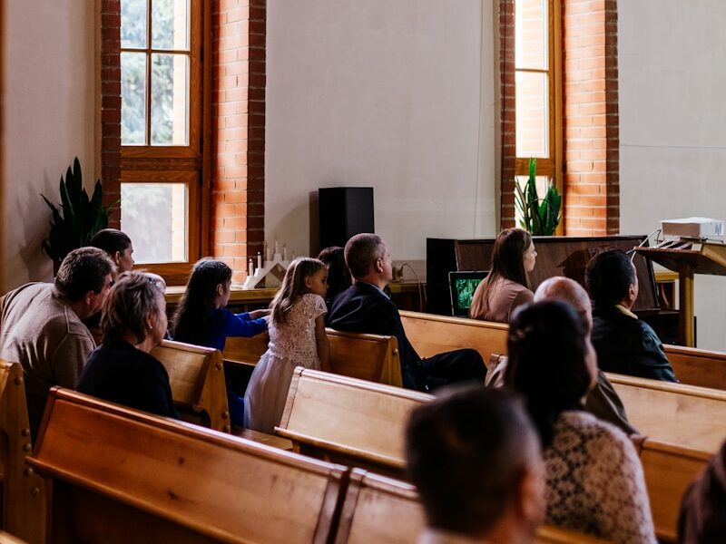 a group of people sitting in pews in a church