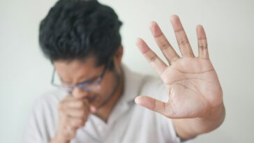 a man holding his hand up in front of his face