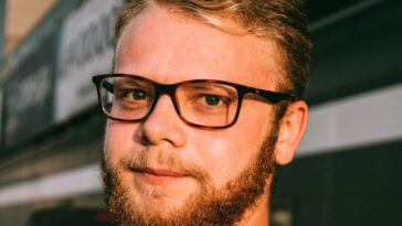 man in white crew neck shirt wearing black framed eyeglasses