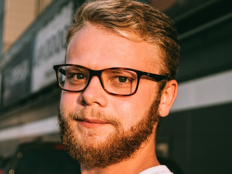 man in white crew neck shirt wearing black framed eyeglasses
