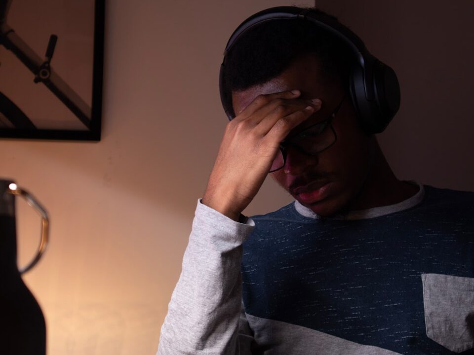 woman in gray sweater covering her face