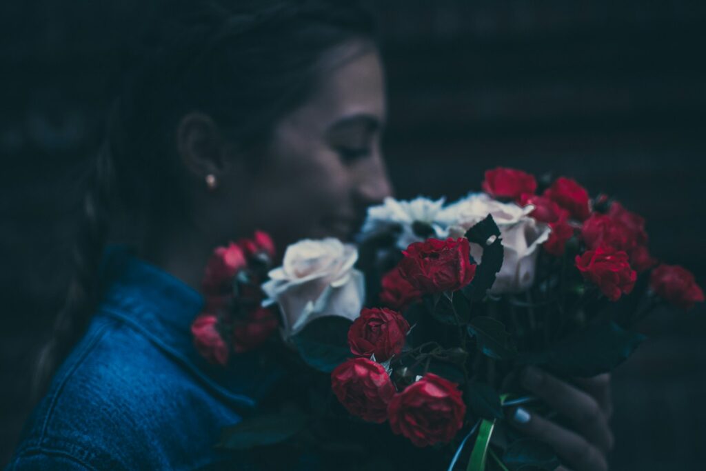 woman holding red and white rose flowers