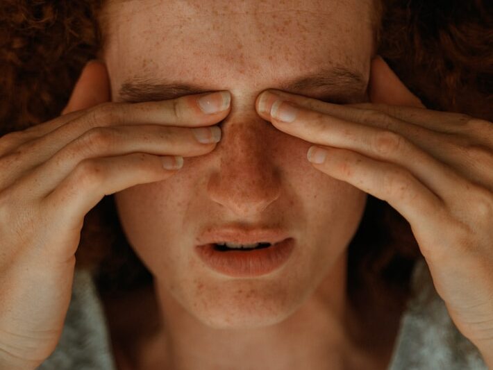 a woman with red hair covering her eyes