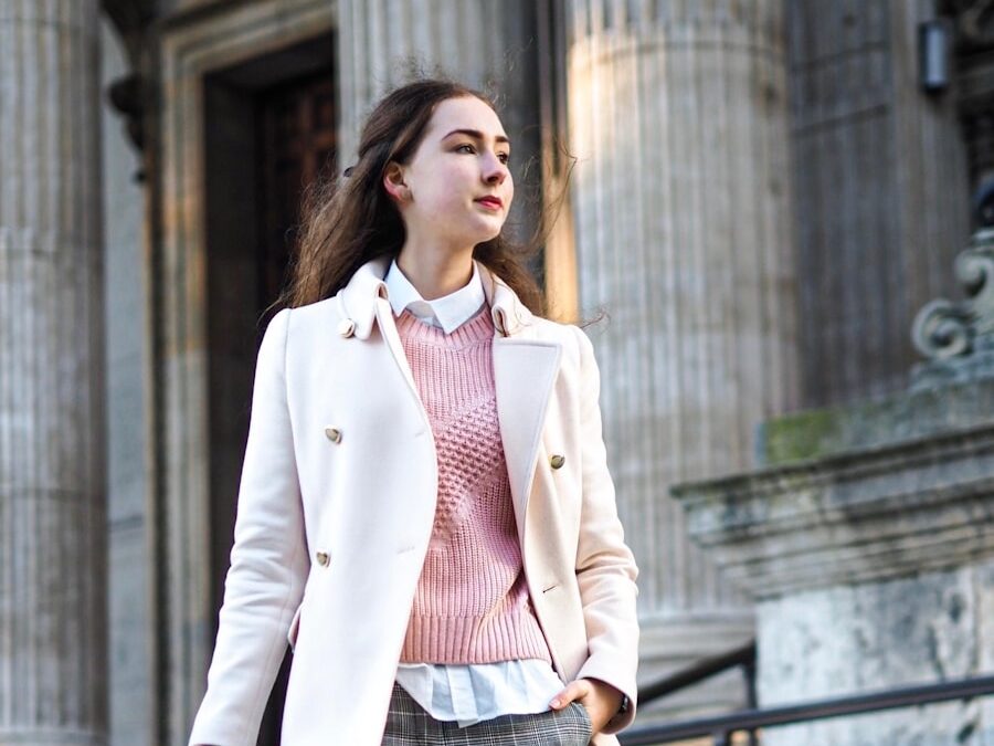woman wearing white coat carrying crossbody bag