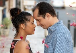 man in white and black checked dress shirt kissing woman in black and white stripe dress