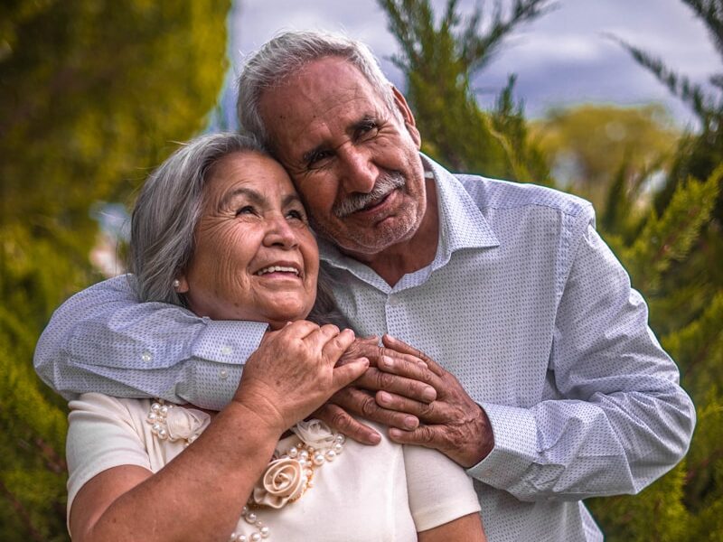 man in white dress shirt hugging woman in white dress