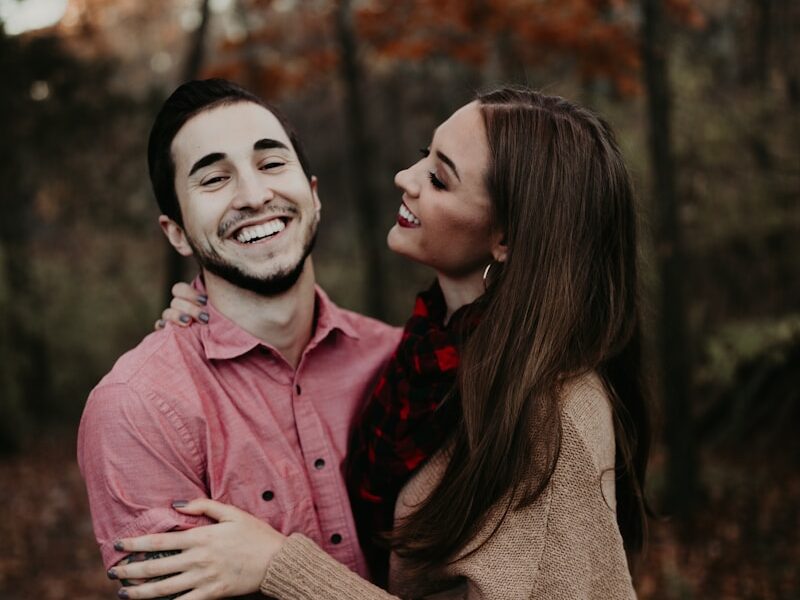 woman hugging man selective focus photography