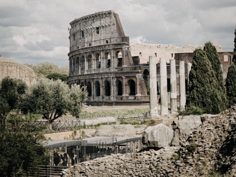 people standing near Colosseum in Rome, Italy under white and blue skies during daytime