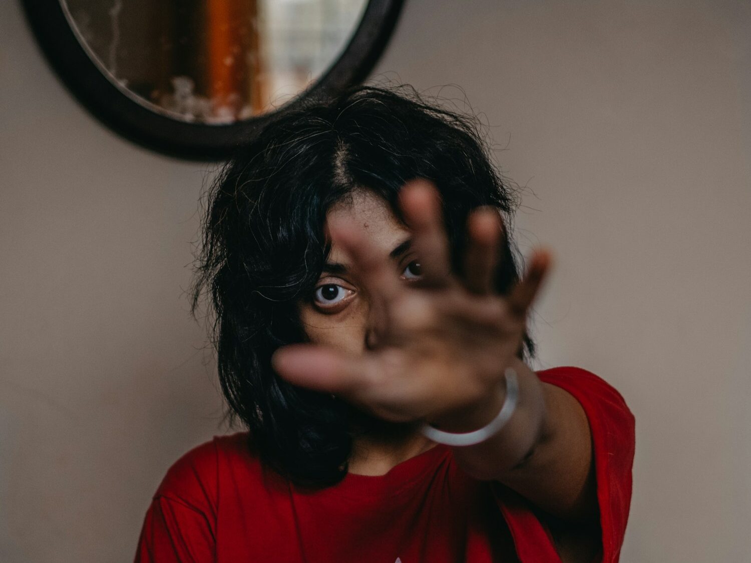 a woman making a hand gesture in front of a mirror