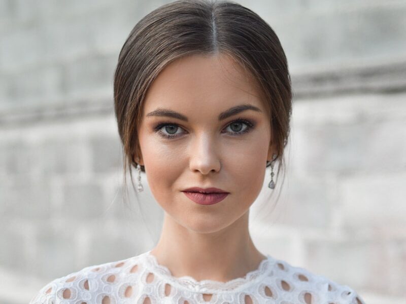 shallow focus photo of woman standing near wall